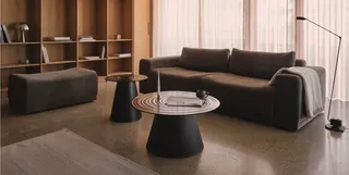 Dark sofa, coffee tables and ottoman in a modern living room.