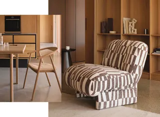 Wood dining furniture and patterned upholstered lounge chair indoors.