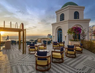 Rooftop terrace with blue and cream outdoor lounge chairs and tables