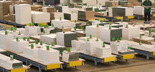 Factory production floor with stacked sheet materials on carts