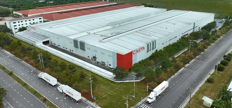 Aerial view of a large furniture factory with branded delivery trucks