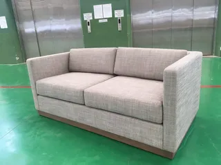 Light gray upholstered three-seat sofa in a factory