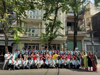 Large company team group posing outside a building