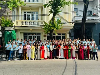 Company staff group posing outside an office building