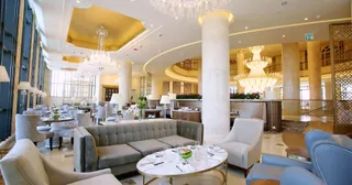 Hotel lounge interior with sofas, armchairs, tables and chandeliers