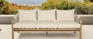 Three-seat outdoor sofa with cream cushions and wooden frame