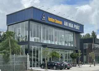 Modern glass-fronted furniture showroom with AN HOA PHAT signage