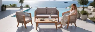 Wicker armchairs, sofa and wooden coffee table beside an infinity pool