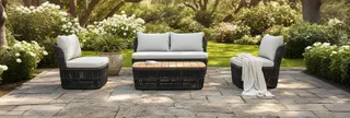 Outdoor sofa and armchairs with woven bases in a garden
