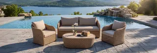 Wicker sofa, two armchairs and round coffee table beside a pool