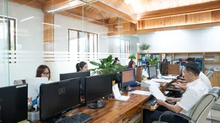 Office staff working at desks in a wood-furnished workplace