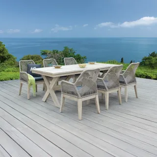 Woven outdoor dining table and six chairs on a seaside terrace