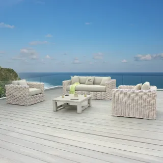 Woven outdoor sofa, armchairs and coffee table overlooking the sea