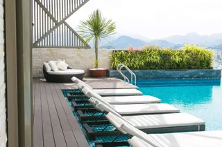 Row of outdoor sun loungers beside a swimming pool
