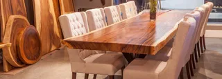 Large live-edge wooden dining table surrounded by upholstered dining chairs.