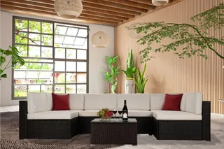 Woven outdoor sectional arranged in a bright wood-paneled interior