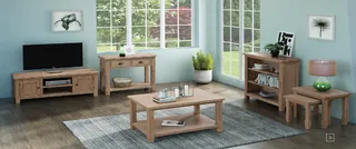 Wooden TV console, coffee table, side tables and shelving in a bright living room.