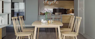 Wood dining table and spindle-back chairs in a modern open-plan interior.