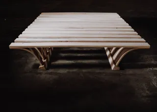 Low wooden table with slatted top and curved supports