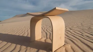 Light curved wooden table or stool in a desert landscape