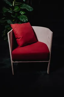 Light wooden armchair with a red upholstered seat and cushion