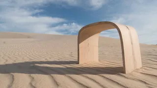 Arched light wooden furniture piece in a sandy landscape