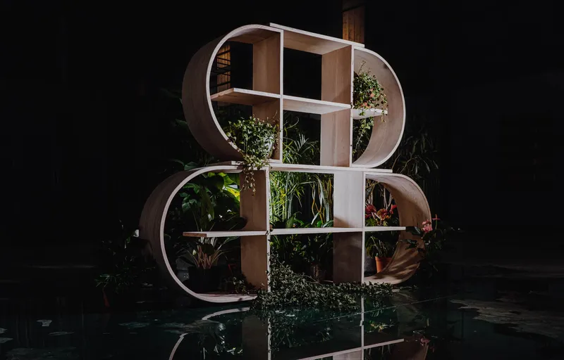 Circular wooden shelving unit with plants and square compartments