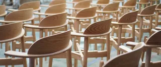 Rows of wooden chairs with curved backrests in a furniture display.
