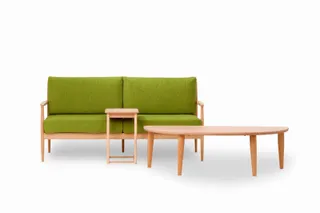 Green upholstered sofa with wooden side table and coffee table.
