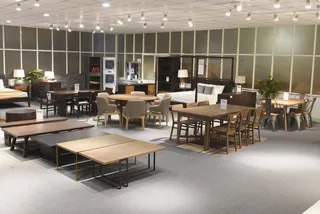 Furniture showroom displaying dining tables, chairs, beds, cabinets and sideboards