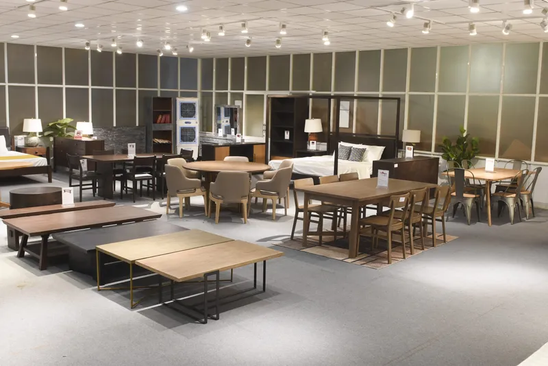 Furniture showroom displaying dining tables, chairs, beds, cabinets and sideboards