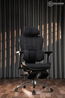 Black padded ergonomic office chair photographed against dark curtains