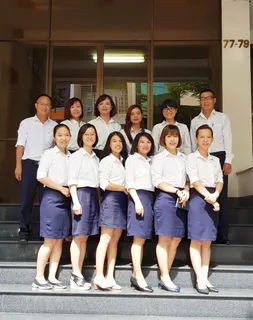 Company staff posing on the steps outside an office