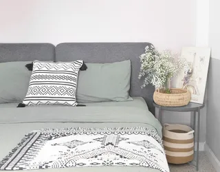 Woven basket beside a grey sofa and patterned throw