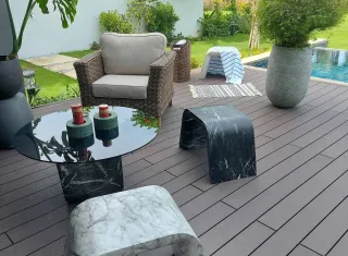 Outdoor patio furniture arranged on a poolside deck