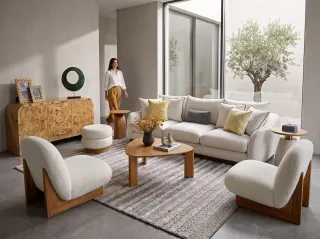 Living room furnished with sofas, lounge chairs, tables and a wood-front sideboard