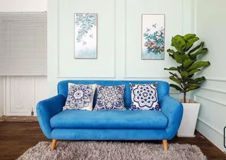 Blue two-seat upholstered sofa with patterned cushions