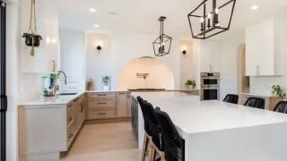 Light kitchen cabinetry and large white island in a finished home interior