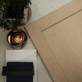 Light wood cabinet panel with dark finish samples and a glass bowl
