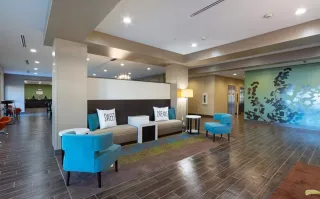 Finished hospitality lobby with sofas, blue lounge chairs, tables and reception desk