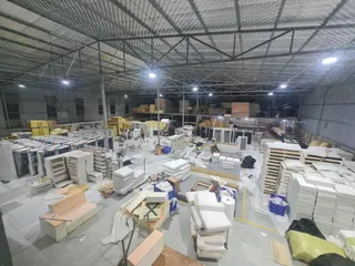 Large furniture factory floor with production workstations and stacked components