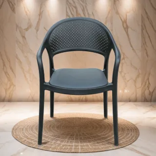 Black perforated armchair on a round woven rug