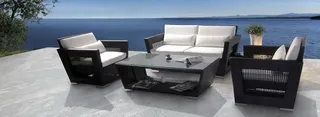 Black and white woven outdoor sofa set with coffee table overlooking the sea