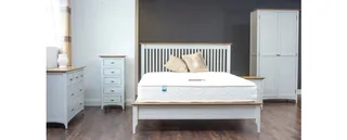 White wooden bed with wardrobe, dresser and bedside tables.