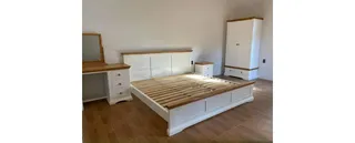 White wooden bed, wardrobe, dresser and bedside furniture.