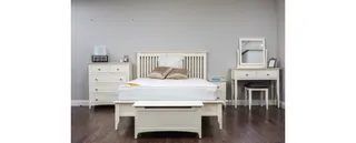 White wooden bed with matching dresser, vanity, bedside table and bench.