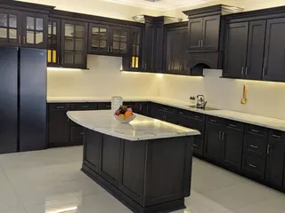 Dark wood kitchen cabinetry with central island and built-in appliances