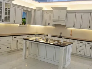 White fitted kitchen with central island and glassware