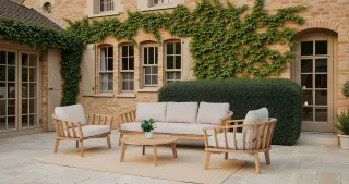 Outdoor wooden sofa, armchairs and coffee table arranged on a paved patio