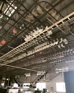 Furniture factory production floor with overhead conveyor and suspended components